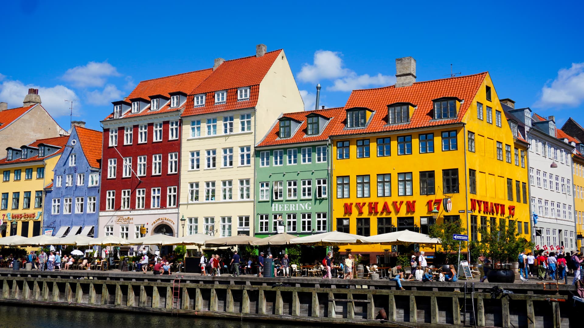 Colourful Nyhavn waterfront houses in Copenhagen under a bright blue sky